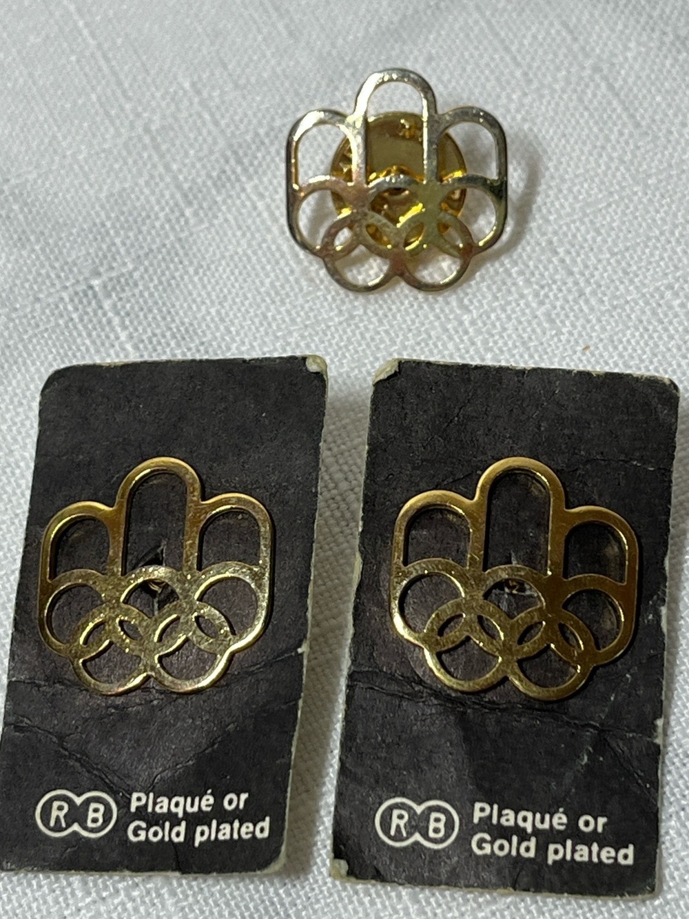 Vintage 1976 Montreal Summer Olympic Games pins featuring a gold-plated design
